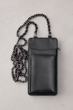 a black leather wallet with chain attached to it on a white surface, next to an empty cell phone case