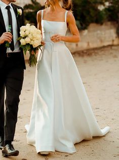 the bride and groom are walking down the street