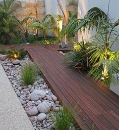 a wooden deck surrounded by plants and rocks