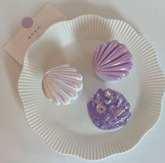 three seashells are sitting on a paper plate