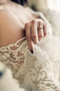 a woman in a wedding dress pointing her finger at the camera while wearing a ring