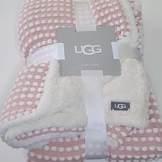 the ugg pink and white checkered towel is folded up on a white surface