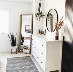 an instagram photo of a bedroom with white furniture and plants on the dressers