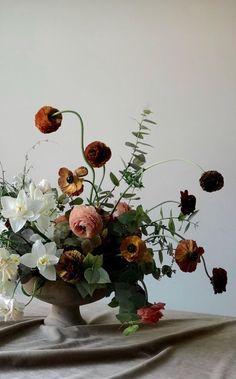 a vase filled with lots of flowers on top of a table