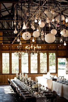 an image of a dining room with chandeliers hanging from it's ceiling