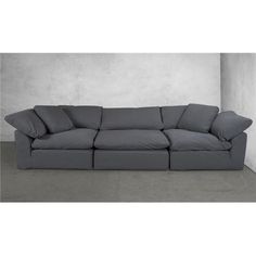 a large gray couch sitting in front of a white wall