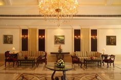 an elegant hotel lobby with chandelier and couches