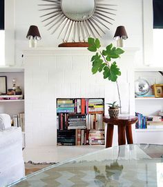 a living room filled with furniture and a large sunburst above the fire place