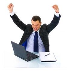 a man sitting at a desk with his arms in the air and laptop on his lap