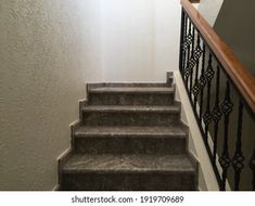 an image of stairs going up to the second floor in a house or apartment with white walls and wood handrails