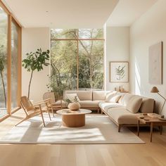 a living room filled with lots of furniture and large glass windows on the side of it