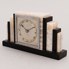 a small clock made out of marble blocks