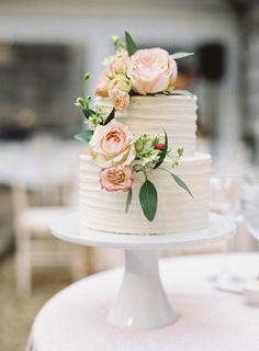 a white wedding cake with flowers on top