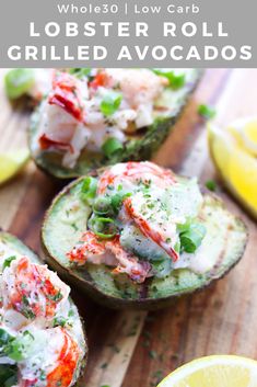 crab salad in avocado halves on a cutting board with lemons and lime wedges