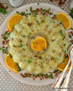 a white plate topped with rice covered in orange slices and garnished with nuts