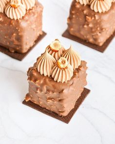 three pieces of chocolate cake sitting on top of each other with gold decorations around the edges