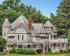 a large white house surrounded by trees and bushes