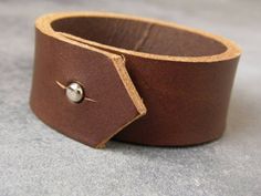 This beautiful leather bracelet was made using high quality leather and will wear wonderfully with age. The leather cuff is provided with a strong silvery rivet, for a quick and easy closure.Guidelines : ● 2.2 cm (7/8") wide● 3 mm thick ●15 cm (approx 6") long It will definitely add a sweet touch to your outfit! With it's simple design, this boho bracelet would also make an amazing 3rd anniversary gift ! ***Thank you for visiting AdSaggitam! :) Waxed Finish Leather Cuff Bracelet As Gift, Brown Leather Cuff Bracelet For Everyday, Everyday Brown Leather Cuff Bracelet, Modern Leather Cuff Bracelet, Brown Everyday Cuff Bracelet, Everyday Brown Cuff Bracelet, Leather Cuff Bracelet With Rivets, Classic Handmade Leather Cuff Bracelet, Brown Leather Cuff Bracelet With Strap