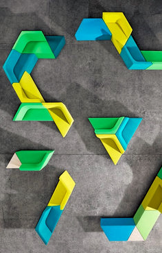 an overhead view of colorful furniture on concrete flooring with geometric shapes in the middle