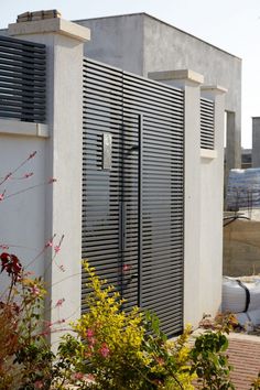 an outdoor storage unit with shutters on the doors and side walls, in front of a building