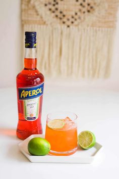 a bottle of apricot next to a glass with an orange and lime on it