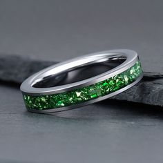 a wedding band with green stones on it