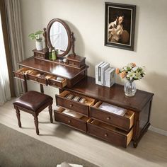 a dressing table with drawers and stools in a room next to a painting on the wall