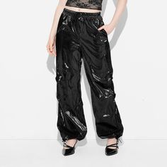 Twill baggy parachute pants from Wild Fable™ in solid black with a shiny finish. Made from midweight recycled polyester. Tailored in a relaxed fit with an elasticized waistband and drawstring plus cuffs with adjustable drawcord fastening. Two side pockets complete the design with functional flair. If you're not satisfied with any Target Owned Brand item, return it within one year with a receipt for an exchange or a refund. Wild Fable™: A look for every story. Black Shiny Bottoms For Fall, Shiny Black Bottoms For Fall, Fall Black Shiny Bottoms, Solid Color Parachute Pants For Streetwear, Solid Parachute Pants With Loosely Fitted Hips For Streetwear, Trendy Black Baggy Parachute Pants, Summer Streetwear Nylon Parachute Pants, Casual Metallic Bottoms With Elastic Waistband, Trendy Black Parachute Pants For Fall