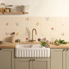 a white sink sitting under a window next to a wooden counter top in a kitchen