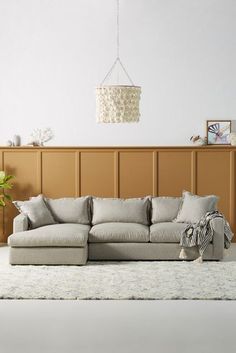 a living room with a couch, rug and lamp hanging from the ceiling above it