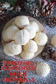 a bowl filled with snow covered cookies next to pine cones