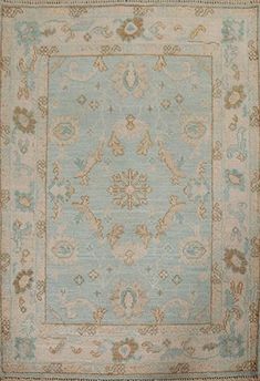 a blue and beige rug with an ornate design on the center, surrounded by smaller flowers