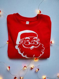 **Sweatshirt only** Check for sizing details in pictures! Vintage Santa Crewneck Sweatshirt, Red Kids Sweatshirt, Christmas Shirt, Toddler Christmas Outfit, Kids Christmas Outfit, Christmas Party 2T-size 7 is Rabbit Skins brand and is 60/40 cotton/polyester Youth Small-Youth Large is Gildan Brand and is 50/50 preshrunk cotton/polyester Thank you for shopping small, it means so much to us! -Emily and Chad Red Long Sleeve Christmas T-shirt, Christmas Crew Neck Cotton Sweater, Christmas Cotton Crew Neck Sweater, Festive Christmas Crew Neck Sweatshirt, Christmas Cotton Sweatshirt With Graphic Print, Christmas Cotton Crew Neck Sweatshirt, Red Holiday Sweatshirt For Winter, Holiday Cotton Sweatshirt With Graphic Print, Red Christmas Tops With Letter Print