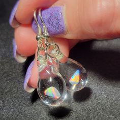 "My friend Marcy named this style of earrings. She said they look like Mermaid's tears. These teardrop dangle earrings are crafted by melting borosilicate glass tubing (pyrex) and blowing a bubble at the end of the tube in the flame, encasing a white Gilson opal nugget inside. The opal flashes with blue, green, yellow, and red hues within the glass. Only first-quality borosilicate glass and a blowtorch fueled by oxygen and propane are used, and the pieces are annealed in a digitally controlled e Glass Drop Earrings With Matching Set, Glass Teardrop Jewelry With Matching Earrings, Nickel-free Glass Drop Jewelry, Glass Drop Earrings As Gift, Nickel-free Teardrop Glass Jewelry, Nickel-free Glass Teardrop Jewelry, Hypoallergenic Teardrop Glass Jewelry, Hypoallergenic Glass Teardrop Jewelry, Unique Iridescent Teardrop Earrings