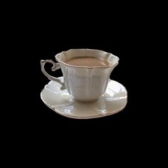 a coffee cup and saucer on a black background