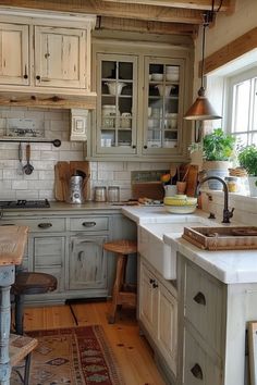 an old fashioned kitchen with wooden floors and white painted cabinets is pictured in this image