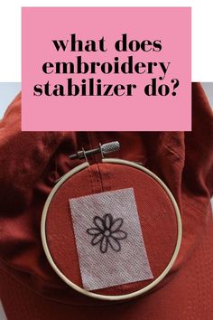 a red hat with the words what does embroidery stabilizer do? on it's side