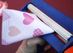 a person is holding some paper with hearts on it