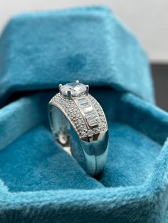 an engagement ring in a blue velvet box with diamonds on the sides and inside it