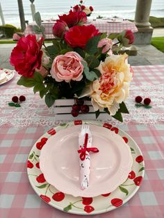 the table is set with pink and red flowers