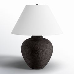 a black table lamp with a white shade on the base and a light at the end