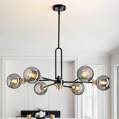 a modern chandelier hangs over a dining room table