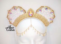 Another version of the original Arabian Princess Ears, this time with iridescent coloring so that brilliant color flashes of every range are present. Like the originals, these are covered in sparkle and dripping with gorgeous jewels and medallions, just enough to exude the essence of royalty! Made to Order. *Hanging charms may differ depending on availability* Minnie Outfit, Arabian Princess, Disney Wear, Disneyland Ears, Disney Minnie Mouse Ears, Chain Headpiece, Disney Ears Headband, Disney Headbands, Diy Disney Ears