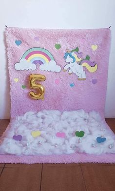 a unicorn themed birthday card with balloons and confetti on the bottom, in front of a white wall