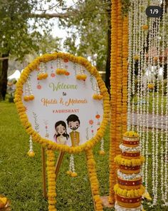 a welcome sign is decorated with flowers and garlands for the couple's wedding