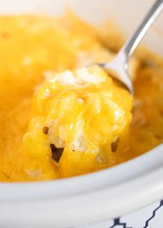 a close up of a spoon in a crock pot filled with macaroni and cheese