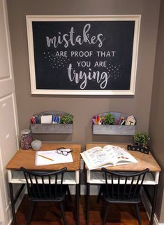 two desks with chairs and a chalkboard on the wall above them that says, make