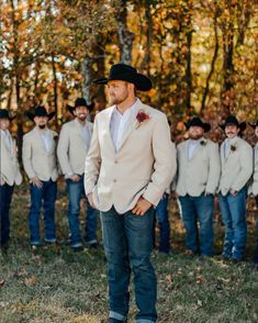 a man standing in front of a group of men wearing suits and ties with hats on