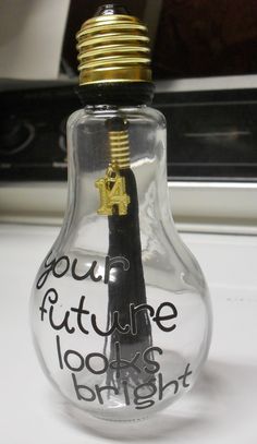 a glass bottle with writing on it and a light bulb in the shape of a handwritten message