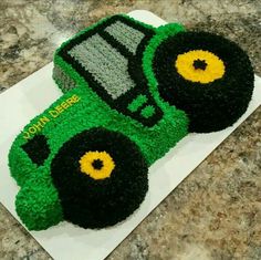 there is a cake made to look like a green tractor on top of the table